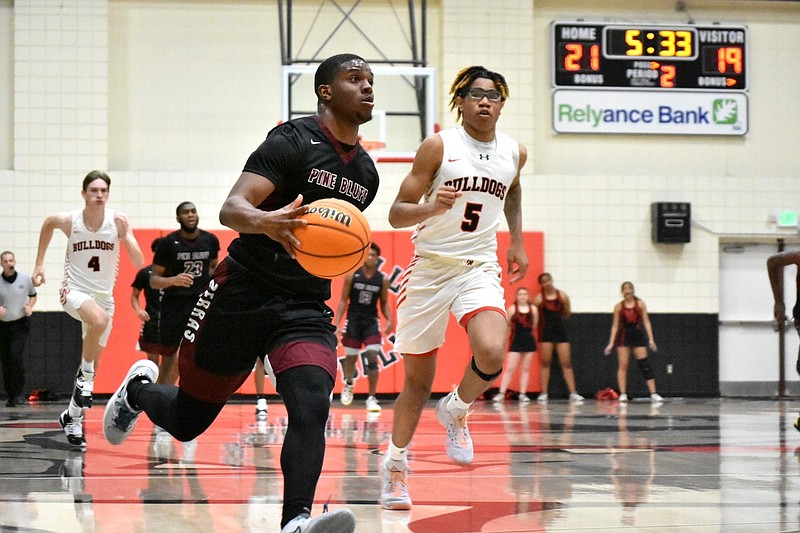 X’Zaevion Barnett of Pine Bluff dribbles in transition for a basket against Jai’Chaunn Hayes (5) of White Hall in the second quarter Thursday at White Hall’s Bert Honey Gymnasium. (Pine Bluff Commercial/I.C. Murrell)