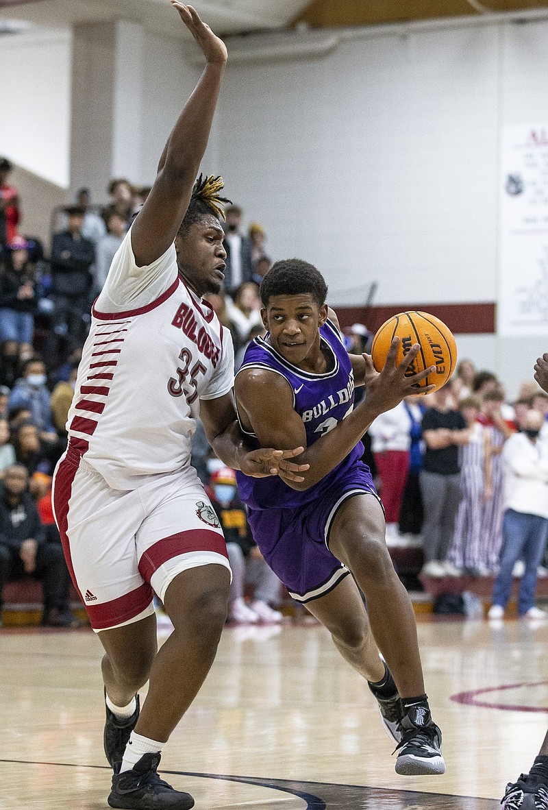 Fayetteville’s Ornette Gaines (right) drives to the basket as Springdale’s
Tevin Tate defends during Friday’s game in Springdale.
Gaines scored 23 points in the Bulldogs’ 67-35 victory.
(Special to the NWA Democrat-Gazette/David Beach)