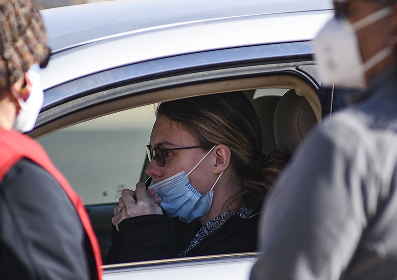 A woman swabs her nose for a covid-19 test under the direction of Ector County Health Department staff Friday in Odessa, Texas. White House officials said Friday that free rapid coronavirus tests ordered from covidtests.gov have started shipping.
(AP/Odessa American/Eli Hartman)