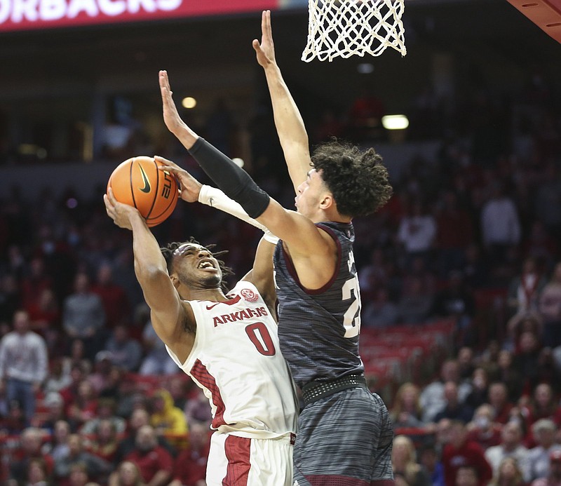 Arkansas guard Stanley Umude (left) shoots as Texas Arlington’s Andre Gordon defends during the first half Saturday at Walton Arena in Fayetteville. Umude finished with 15 points and seven rebounds as the Razorbacks won 76-73 in overtime. More photos at arkansasonline.com/123tamua/
(NWA Democrat-Gazette/Charlie Kaijo)