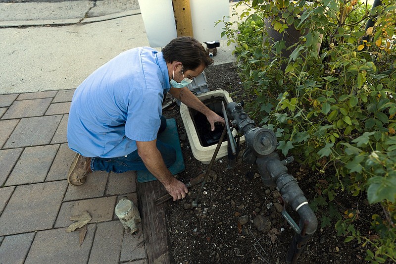 Cason Gilmer, a senior field customer service representative from the Las Virgenes Municipal Water District, installs an advanced water metering system in Agoura Hills, Calif., earlier this month.
(AP/Jae C. Hong)