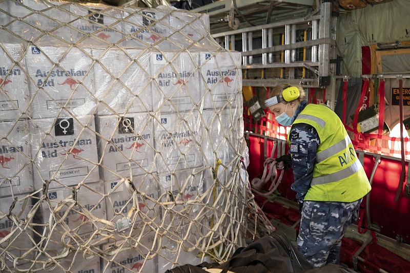 A worker conducts a pre-flight check Friday on humanitarian assistance and supplies aboard a C-130J Hercules aircraft at RAAF Base Amberley in Australia. The aid-laden plane was headed to Tonga.
(AP/Australian Defense Force/Kate Czerny)
