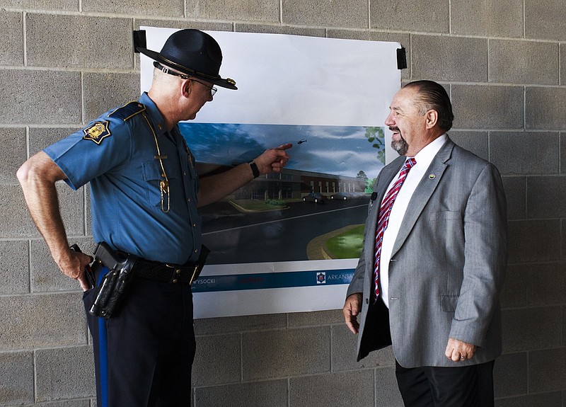 FILE — Arkansas State Police Sgt. Marty Pollock (left) and Lowell Mayor Eldon Long look at a picture of the new Arkansas State Police headquarters, Friday, July 27, 2018 at its new location in Lowell. (NWA Democrat-Gazette/CHARLIE KAIJO)