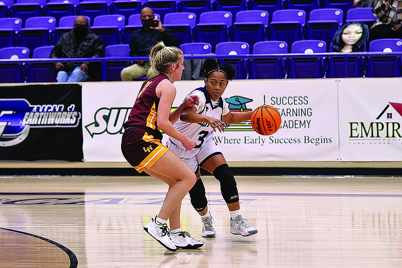 El Dorado's Charalyn Rester tries to maneuver around a Lake Hamilton defender. The Lady Wolves won 65-40 Friday night in Wildcat Arena.