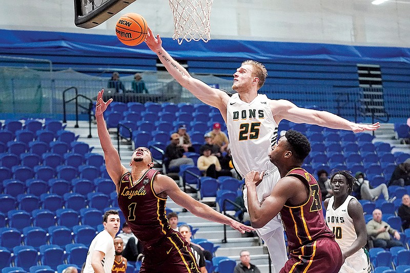 In this Jan. 6 file photo, San Francisco forward Yauhen Massalski blocks the shot of Loyola guard Lucas Williamson during a game in Taylorsville, Utah. Struggling to find opponents amid the coronavirus chaos, San Francisco and Loyola of Chicago decided to meet in the middle. (Associated Press)