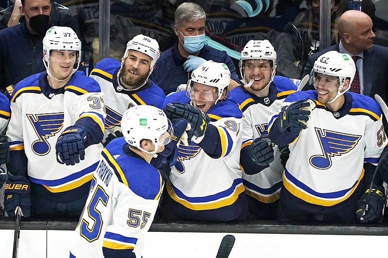 The Blues lean forward to congratulate teammate Colton Parayko after his penalty-shot goal Friday night against the Kraken in Seattle. (Associated Press)