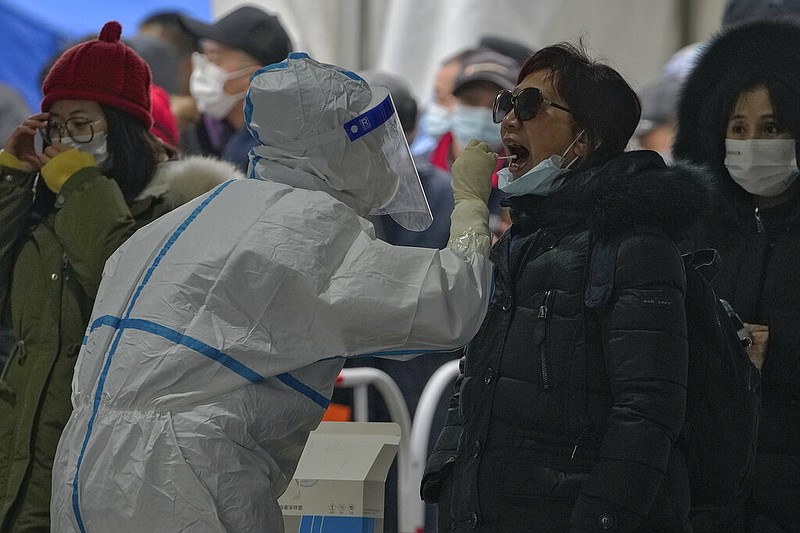 A woman get a throat swab at a mass coronavirus testing site in Beijing, Monday, Jan. 24, 2022. (AP/Andy Wong)