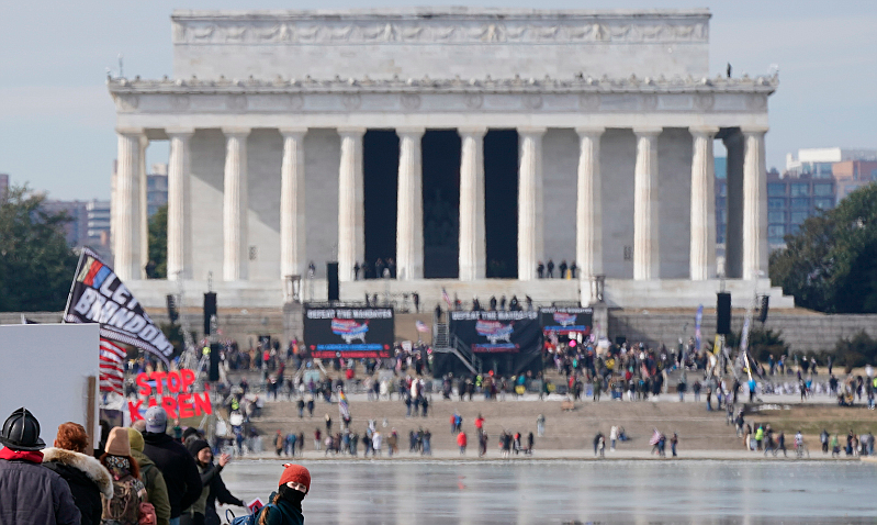 People march alongside the Lincoln Memorial Reflecting Pool before an anti-vaccine rally, Sunday, Jan. 23, 2022, in Washington. (AP Photo/Patrick Semansky)