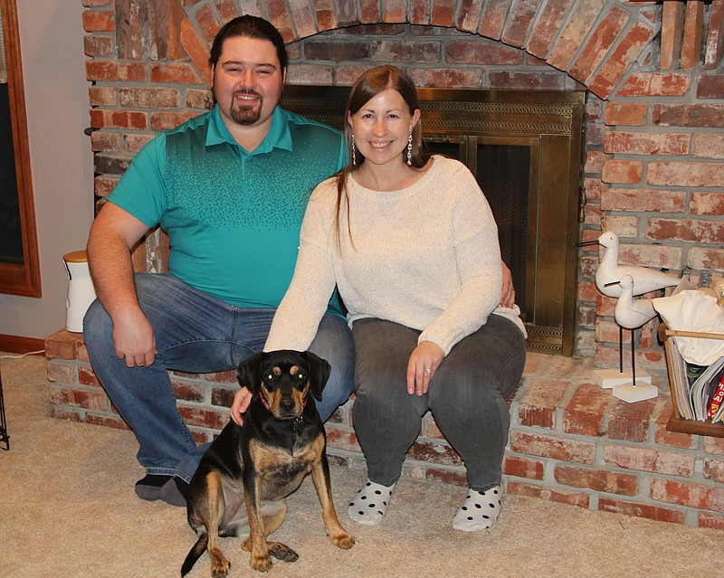 Newlyweds James and Whitney Scurlock pose with their rescue dog, Bailey.