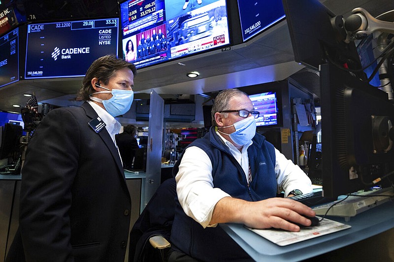 In this photo provided by the New York Stock Exchange, trader Michael Conlon, right, works on the floor, Tuesday, Jan. 25, 2022. (Allie Joseph/New York Stock Exchange via AP)