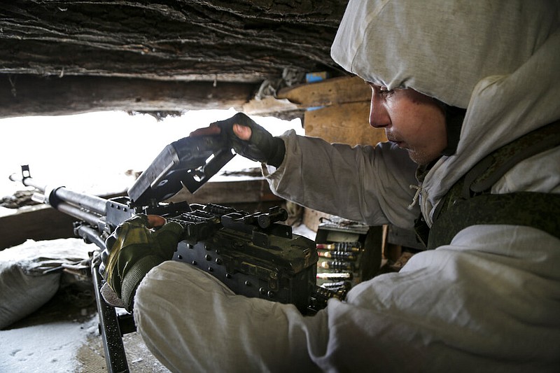 A serviceman checks his machine-gun in a shelter on the territory controlled by pro-Russian militants at frontline with Ukrainian government forces in Slavyanoserbsk, Luhansk region, eastern Ukraine, Tuesday, Jan. 25, 2022. (AP/Alexei Alexandrov)