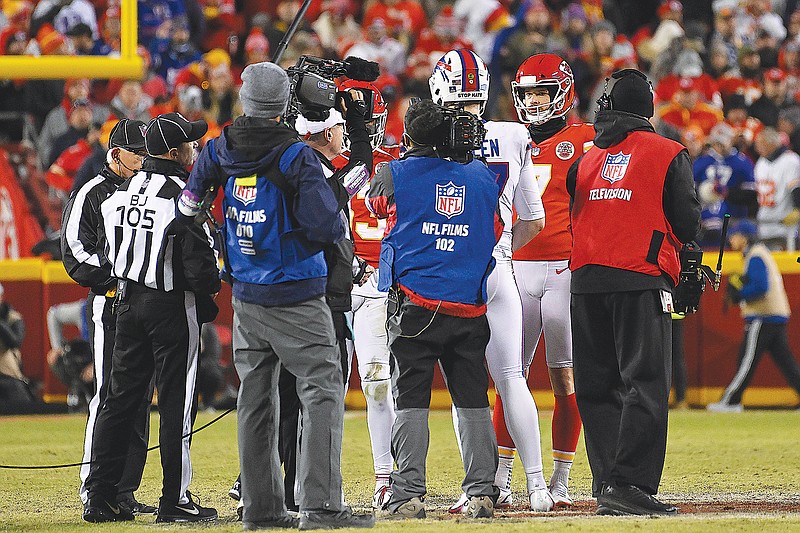 Players and officials meet at midfield for the coin toss prior to the start of overtime in Sunday night’s game between the Chiefs and Bills at Arrowhead Stadium. (Associated Press)