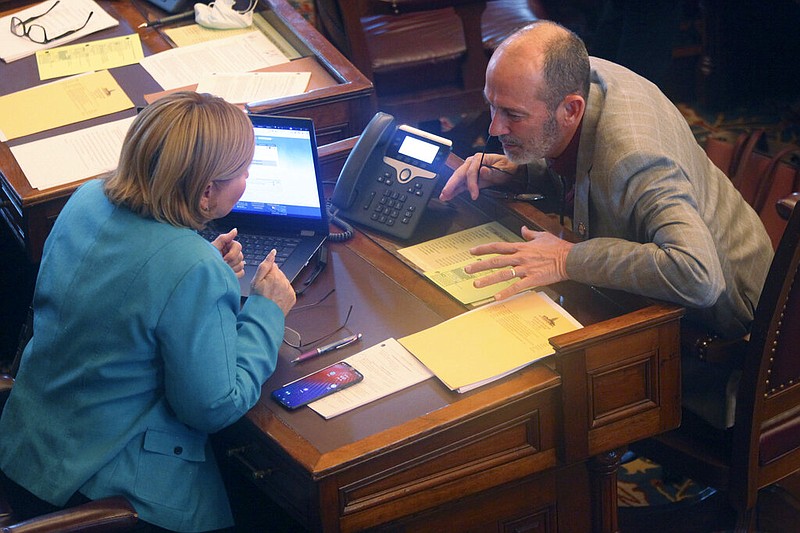Kansas state Sens. Caryn Tyson (left), R-Parker, and Mark Steffen, R-Hutchinson, confer at the Statehouse in Topeka, Kan., in this Feb. 4, 2021, file photo. Steffen, who is also a physician, said Wednesday, Jan. 26, 2022, that he's been under investigation by the state medical board for his public comments about covid-19, dating back even to late 2020, before he was in the Legislature. (AP/John Hanna)