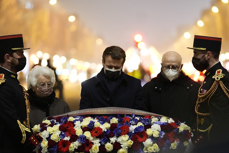 French President Emmanuel Macron, center, flanked by concentration camp survivors, lays flowers under the Arc de Triomphe, Thursday in Paris. More photos at arkansasonline.com/128ihrd22/
(AP/Pool/Thibault Camus)
