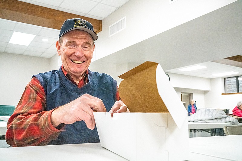 Ron Loesch laughs as he and other volunteers fold boxes in preparation for the Lion Club’s annual Ham & Bean and Chili day on Tuesday, Feb. 1, 2022 at Selinger Exhibit Hall in Jefferson City, Mo. (Ethan Weston/News Tribune photo)