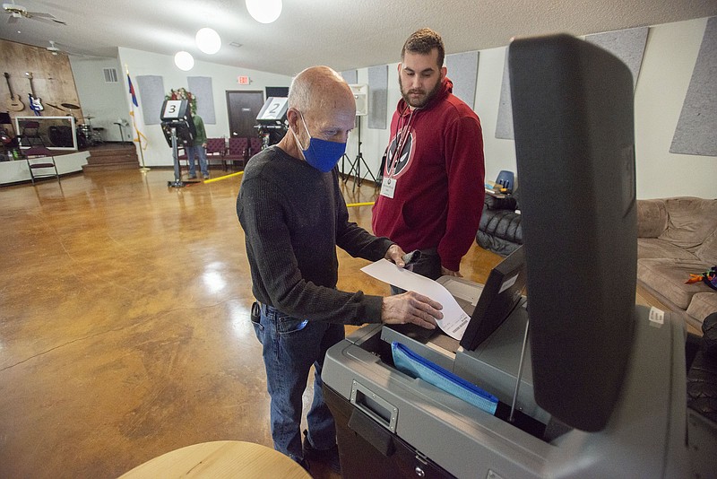 Ricky Stowers of Fayetteville (left) drops his ballot with the assistance of election official Seth Bryant Tuesday Jan. 11, 2022 in the special primary runoff election for filling the vacancy in the office of state senator for district 7 at the Awakening Church in Fayetteville. The general election will be held on February 8, 2022. Visit nwaonline.com/220113Daily/ for today's photo gallery. (NWA Democrat-Gazette/J.T. Wampler)