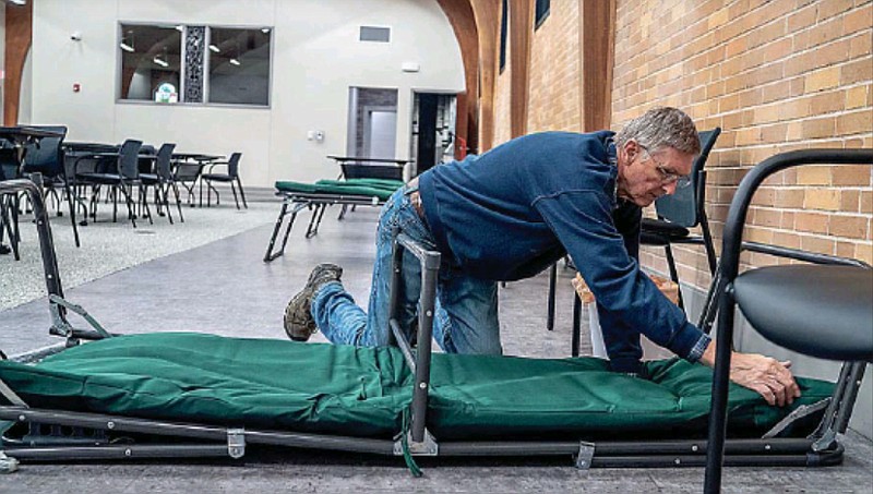 Ron Hanson sets up cots Tuesday, Feb. 1, 2022, for the Jefferson City Rooms at the Inn warming center at Catholic Charities of Central and Northern Missouri. (News Tribune photo)