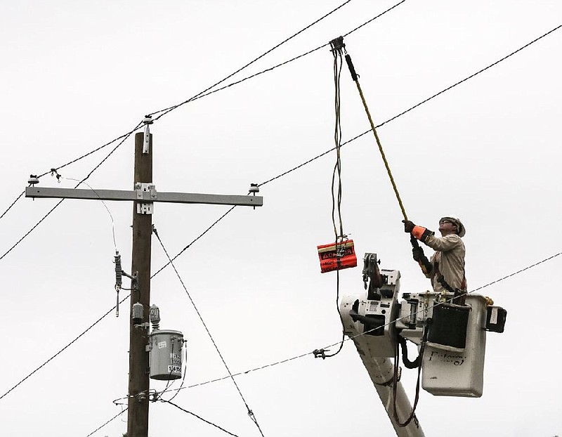 A lineman with Entergy works on power lines along Markham Street in Little Rock in this Oct. 31, 2017, file photo. (Arkansas Democrat-Gazette file photo)