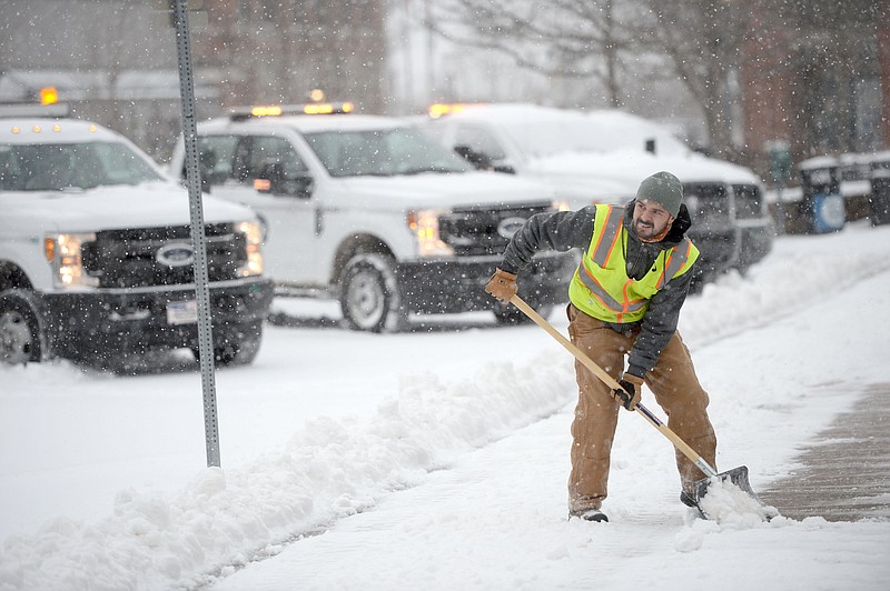 Jose Hernandez with the city of Fayetteville Parks and Recreation Department shovels snow Thursday, Feb. 3, 2022, from the sidewalk on the city?s downtown square as snow falls in Fayetteville. Visit nwaonline.com/220204Daily/ for today's photo gallery. (NWA Democrat-Gazette/Andy Shupe)