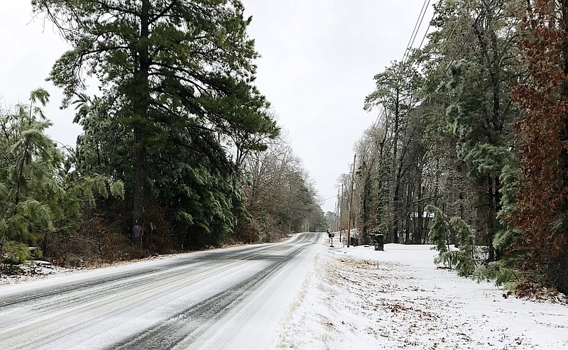 Ice coats pine trees and power lines on the western end of Marion Anderson Road Thursday morning following a mix of winter weather overnight. - Photo by Mark Gregory of The Sentinel-Record