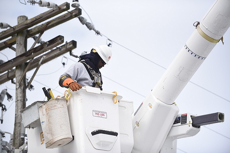 Calvin Reddick, a fourth-year Entergy lineman apprentice, maneuvers the truck’s basket around a damaged power line Friday, Feb. 4, 2022, in Pine Bluff. (Arkansas Democrat-Gazette/Staci Vandagriff)