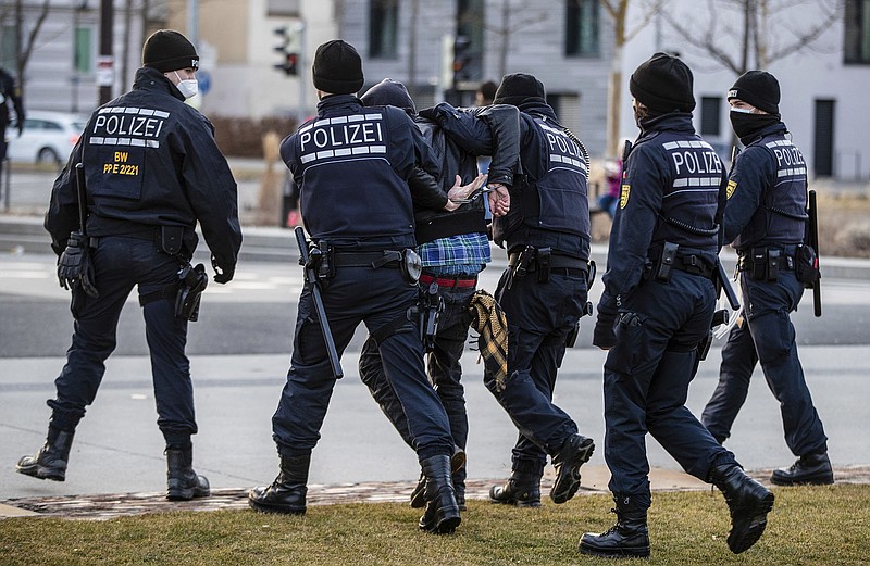 Police officers detain a protester Saturday in Reutlingen, Germany, during a demonstration against the government’s measures to combat the coronavirus. Germany has been slow to relax restrictions, but officials are planning to loosen precautions even though it is setting records for infections daily. More photos at arkansasonline.com/213covid/.
(AP/dpa/Christoph Schmidt)