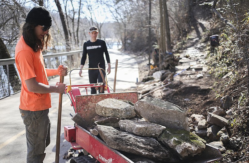 Rocksolid Trail Construction workers Ryan Russell (left) and Caleb Pierce place rocks along a trail entry Thursday at Lake Atalanta in Rogers. Rogers received a grant to update the trails around the lake.
(NWA Democrat-Gazette/Charlie Kaijo)