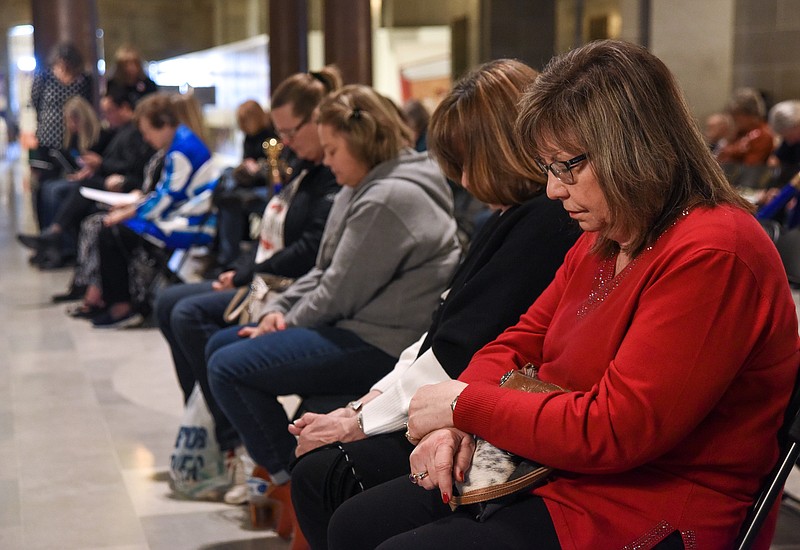 Susan Steiner, near, and Peggy Crabtree Berry bow their heads in prayer Tuesday at the beginning of a rally in the Capitol Rotunda. The women are from Warsaw and are active in political committees and were at the Consent of the Governed rally to support the 7-1 congressional map for Missouri and to tackle other issues in the forefront of today's political landscape. (Julie Smith/News Tribune)