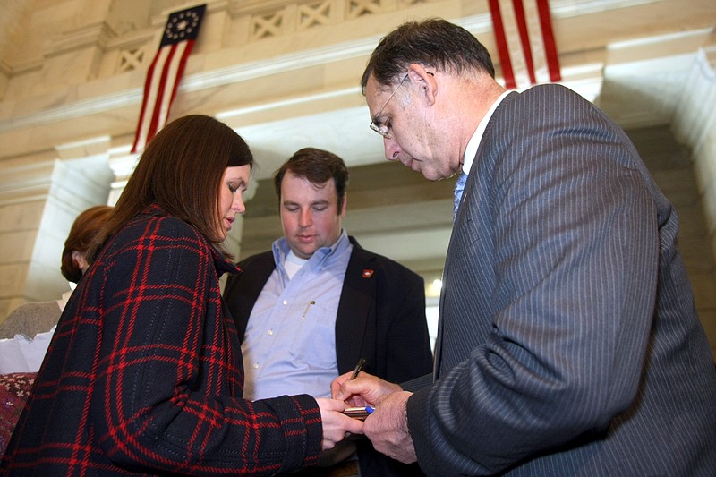 Sarah Huckabee (left), campaign manager for then-U.S. Rep. John Boozman, R-Ark., holds paperwork for Boozman as he files to run for the U.S. Senate in the Capitol Rotunda in Little Rock in this photo taken on March 1, 2010, the first day to file for state and federal offices for the 2010 elections. Chris Caldwell, political director for Boozman for Arkansas, is seen at center. Twelve years later, Boozman is seeking a third term in the U.S. Senate; the now-married Sarah Huckabee Sanders is running for Arkansas governor; and Caldwell is the former chairman of the Delta Regional Authority and Sanders' campaign director. (Arkansas Democrat-Gazette file photo)