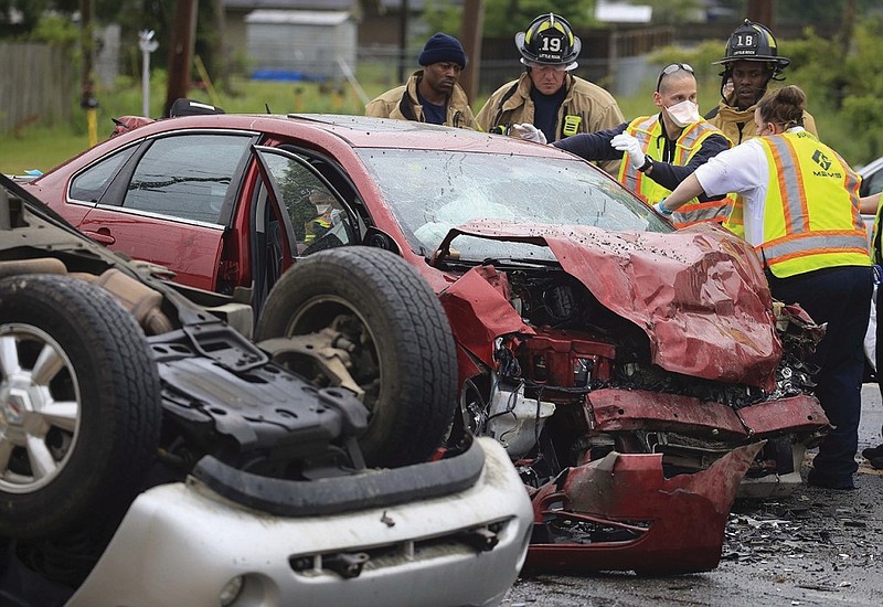 Emergency personnel work to remove the driver of one of two cars involved in a wreck at the intersection of Chico Road and Eagle Drive in Little Rock in this May 12, 2020, file photo. (Arkansas Democrat-Gazette/Staton Breidenthal)