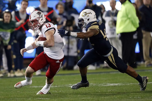 North Carolina State quarterback Devin Leary (13) tries to escape from Georgia Tech linebacker Jordan Domineck (42) during the first half of an NCAA college football game Thursday, Nov. 21, 2019, in Atlanta. (AP Photo/John Bazemore)