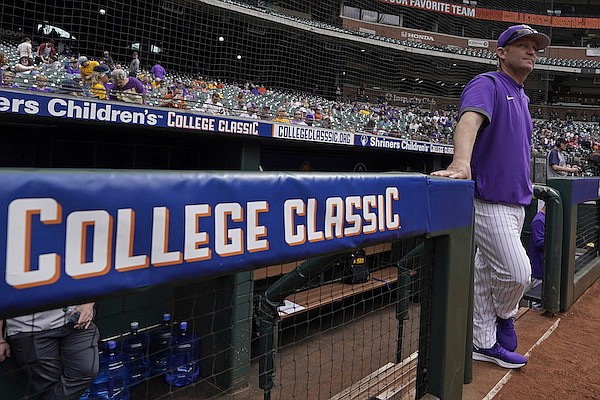 LSU baseball coach Jay Johnson stands at the dugout before an NCAA college baseball game against Oklahoma at Minute Maid Park, home of the Houston Astros, during the Shriners Children's College Classic, Friday, March 4, 2022, in Houston. College baseball might turn out to be an attractive alternative for baseball fans if the Major League Baseball lockout extends deep into the spring. (AP Photo/David J. Phillip)