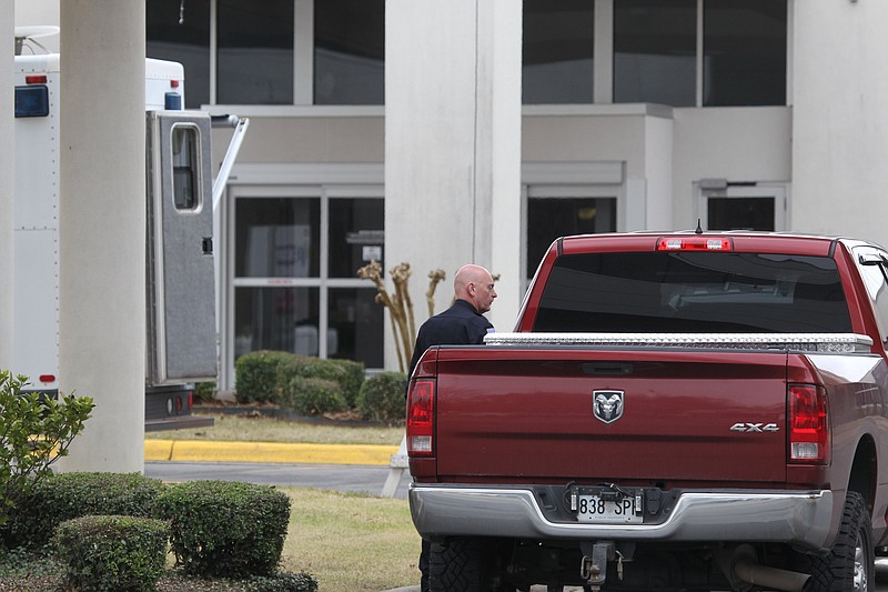 A Pine Bluff police officer stands outside the north entrance to Jefferson Regional Medical Center in this March 11, 2020, file photo. Police were stationed outside the north and south entrances to the hospital as medical personnel just inside the entrances screened visitors after a patient there was determined to have what was then considered a "presumptive" case of covid-19, the first such case of the coronavirus in Arkansas. (Arkansas Democrat-Gazette file photo)