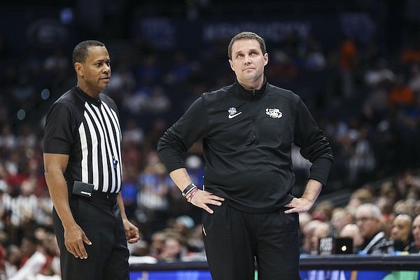 LSU coach Will Wade (right) stands with an official during an SEC Tournament game against Arkansas on Friday, March 11, 2022, in Tampa, Fla.