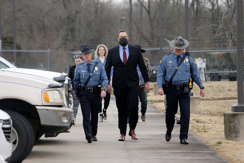 Arkansas State Police troopers escort former Lonoke County sheriff's deputy Michael Davis (center) into the Cabot Readiness Center on Tuesday, March 15, 2022, in Cabot. Jury selection began on Tuesday.
(Arkansas Democrat-Gazette/Thomas Metthe)