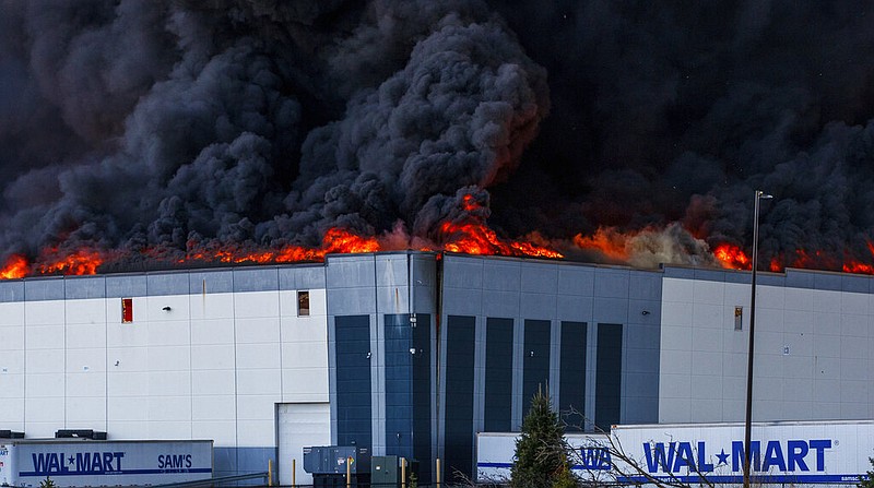A massive fire burns inside a Walmart distribution center in Plainfield, Ind., near the Indianapolis International Airport, Wednesday, March 16, 2022. (Mykal McEldowney/The Indianapolis Star via AP)
