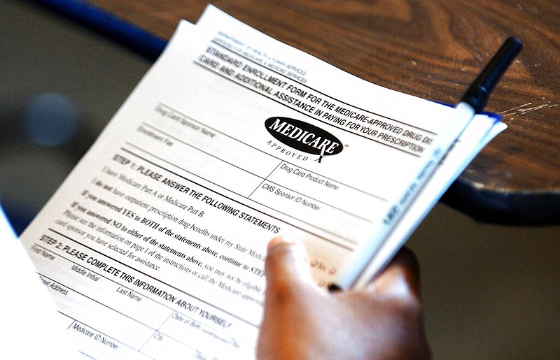 A retiree holds copies of a Medicare-approved drug card application in this undated file photo. (AP/Rogelio Solis)