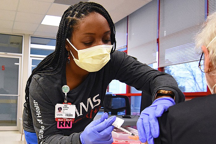 FILE — Andrea Jones, a registered nurse, administers a dose of the coronavirus vaccine Friday at the University of Arkansas for Medical Sciences vaccine clinic at the Monroe Building in Little Rock. The drive-thru site will close at 4 p.m. next Friday. Testing will be available by appointment only beginning March 28 at the Monroe Building.
(Arkansas Democrat-Gazette/Staci Vandagriff)