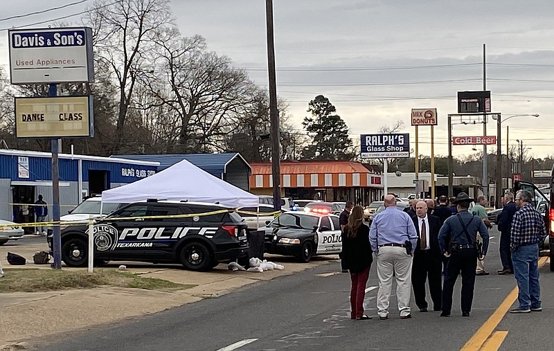 Law officers converse near the scene where two Bowie County fugitives were apprehended during an officer-involved shooting Monday in the 200 block of East Street in Texarkana, Arkansas. (Staff photo)