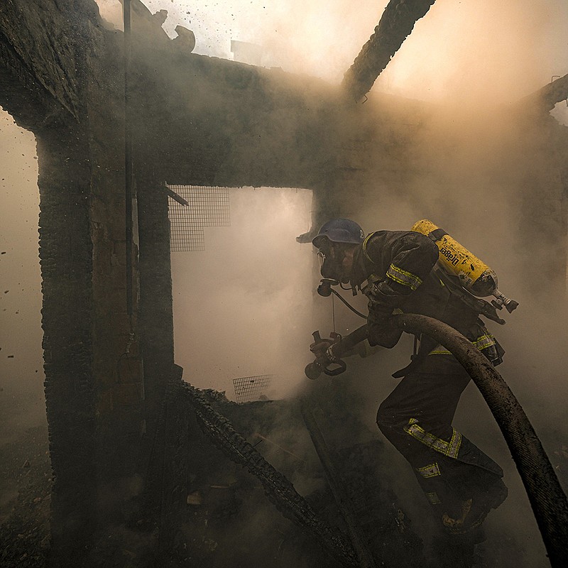 A firefighter sprays water inside a house destroyed by shelling Wednesday in Kyiv, Ukraine. The city has been shaken by near-constant shelling and gunfire as sides battle for control of multiple suburbs.
(AP/Vadim Ghirda)