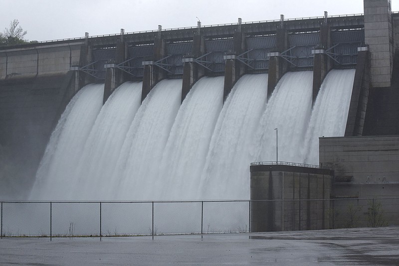 Water roars through the seven sluice gates at Beaver Dam 25 miles northeast of Rogers on Arkansas 187 in this May 2021 file photo. The gates were opened six inches to handle heavy rain, and the flow from those six inches was the equivalent of the flow when one of the dam's two hydroelectric generators is producing electricity at the dam's powerhouse, said Sean Harper, operations manager at the Army Corps of Engineers Beaver Lake office in Rogers. (NWA Democrat-Gazette/Flip Putthoff)
