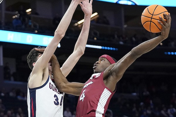 Arkansas guard Davonte Davis, right, shoots against Gonzaga center Chet Holmgren during the first half of a college basketball game in the Sweet 16 round of the NCAA tournament in San Francisco, Thursday, March 24, 2022. (AP Photo/Marcio Jose Sanchez)