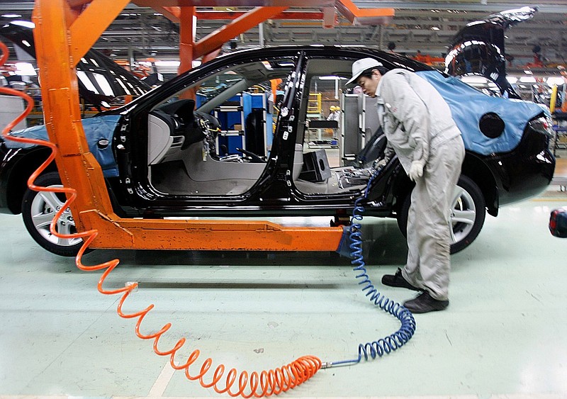 An employee at an auto factory of China’s First Automotive Works Group Corp. in Changchun, northeast China’s Jilin province, works on a production line of sedans in this file photo.
(AP)