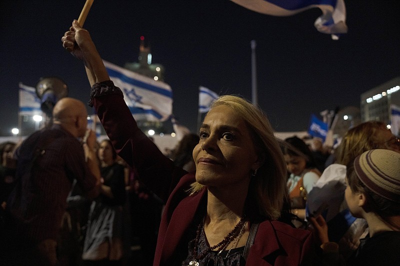 A woman waves the Israeli flag during a right-wing protest Wednesday following a recent wave of violence, in Jerusalem.
(AP/Maya Alleruzzo)