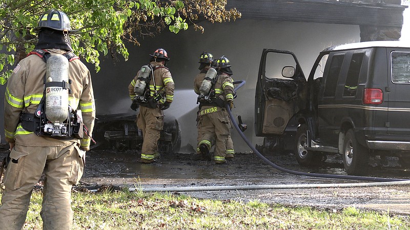 Firefighters work to extinguish a structure fire at 205 Brown St., off Sunset Bay Road, in Hot Springs shortly after 5 p.m. Tuesday. (Hot Springs Sentinel-Record/Donald Cross)