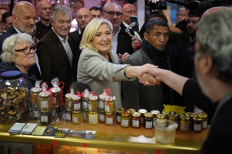 French far-right leader Marine Le Pen shakes hands with a vendor as she tours a food market Friday in Narbonne, southern France.
(AP/Joan Mateu Parra)