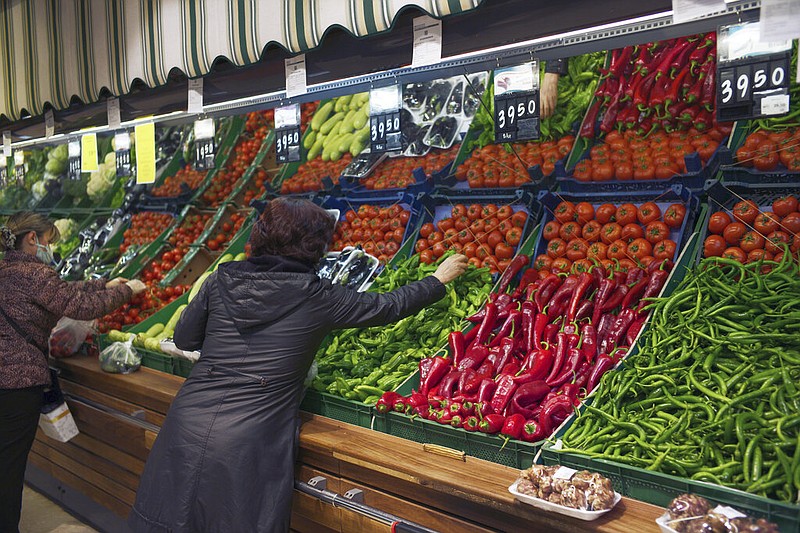 Women buy vegetables at a food market in Ankara, Turkey, on Friday, April 8, 2022. Yearly inflation in Turkey hit 61.14% in March, climbing to a new 20-year high and deepening a cost-of-living crisis for many households. The highest yearly price increase was in the transportation sector, at 99.12%, while the increase in food prices was 70.33%, according to the data. (AP/Burhan Ozbilici)