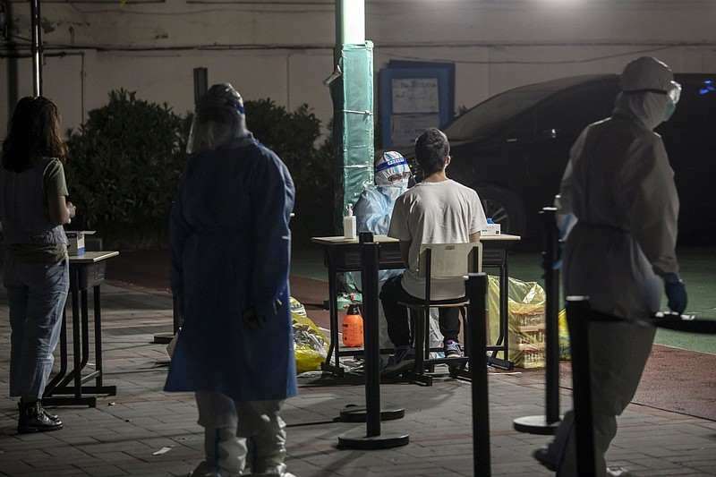 A medical worker swab tests a resident during a round of Covid-19 testing in a neighborhood placed under lockdown in Shanghai on April 12.
(Bloomberg (WPNS)/Qilai Shen)