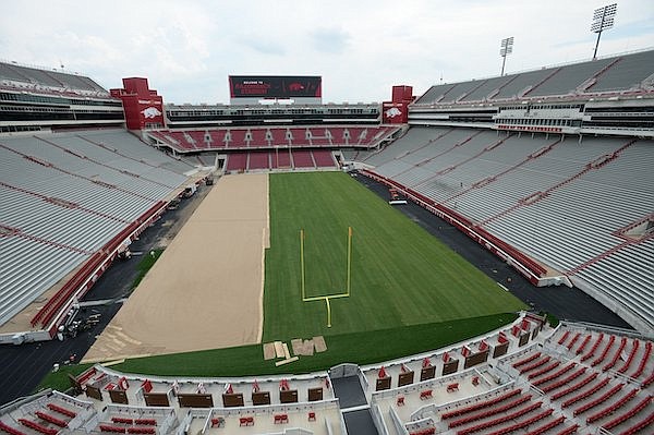 Crews install a grass playing surface Wednesday, Aug. 7, 2019, at Razorback Stadium in Fayetteville.