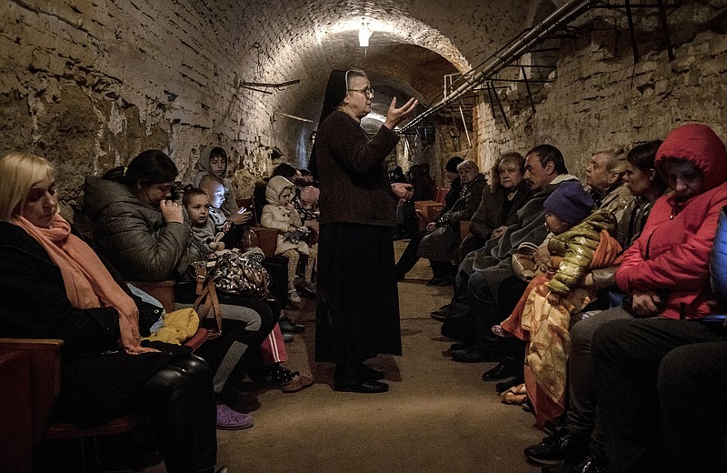 Sister Diogena Tereshkevych tries to comfort fellow civilians with stories Friday while they take refuge in a bomb shelter in the western Ukrainian city of Lviv. More photos at arkansasonline.com/ukrainemonth2/.
(The New York Times/Finbarr O’Reilly)